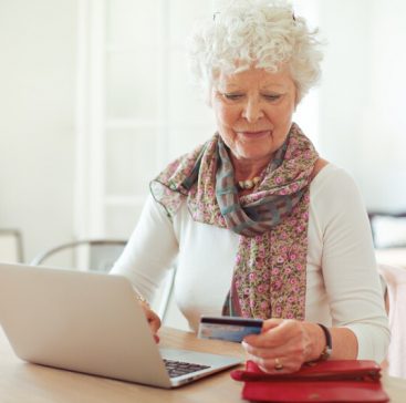 senior woman entering credit card information to do online shopping